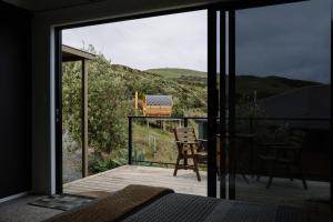a bedroom with a sliding glass door to a balcony at Barrique Studio with Sauna at Barrelled Wines Raglan in Raglan +14 photos