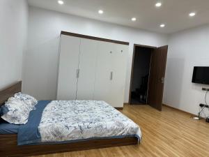a bedroom with a bed and a flat screen tv at MINGO House BA ĐÌNH in Hanoi