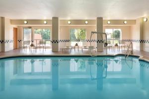 a swimming pool with tables and chairs in a building at Fairfield Inn & Suites Dallas Mesquite in Mesquite