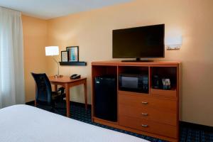 a hotel room with a bed and a flat screen tv at Fairfield Inn by Marriott Richmond in New Paris