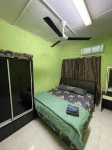 a bedroom with a bed with a ceiling fan at Lylinz Dy Cermai in Pasir Gudang