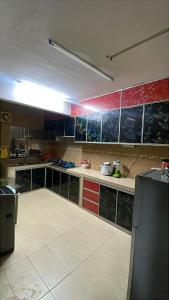 a large kitchen with blue and red cabinets in a room at Lylinz Dy Cermai in Pasir Gudang