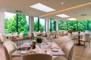 a restaurant with tables and chairs and large windows at Delta Hotels by Marriott Frankfurt Offenbach in Offenbach