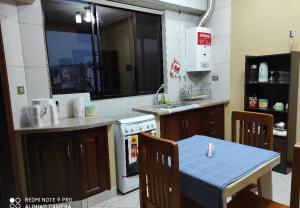a kitchen with a table with a blue table cloth at Departamentos Vacacionales Tarija in Tarija