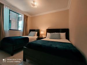 a bedroom with two beds and a window at Departamentos Vacacionales Tarija in Tarija