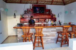 a man standing at a bar in a restaurant at The White Rock Hotel B&B in Los Conucos