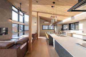 a kitchen and living room with a couch and a counter at Cosmique Chalet Hakuba in Hakuba