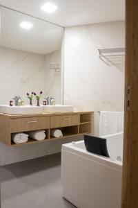ein Badezimmer mit einem Waschbecken und einer Badewanne in der Unterkunft Porto Coliseum Hotel in Porto
