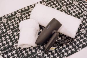 a hair dryer and towels on a table at Nihonbashi Royal in Osaka