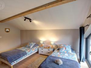 een slaapkamer met twee bedden en een tafel met twee lampen bij Gîte lumineux avec terrasse et animaux acceptés - FR-1-496-155 in Doizieux