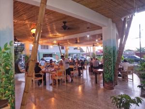 a group of people sitting at tables in a restaurant at Bonding Coffee Roaster Café & Hotel in Quepos