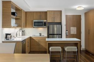 a kitchen with wooden cabinets and a kitchen island with stools at Element Nashville Airport in Nashville