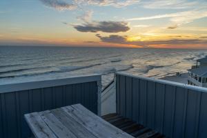a view of the ocean at sunset from a balcony at Strand Castle - GULF FRONT! An ideal layout with game room, small private pool, and roof top crow's nest! home in Dauphin Island