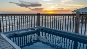 a swimming pool on a deck with the ocean at Strand Castle - GULF FRONT! An ideal layout with game room, small private pool, and roof top crow's nest! home in Dauphin Island