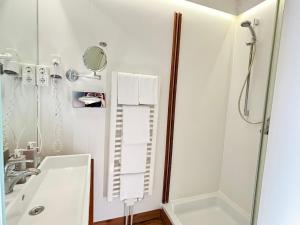 een witte badkamer met douche en wastafel bij Pier 11 im Pierspeicher in Kappeln +6 foto's