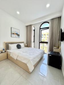 a bedroom with a large bed and a large window at Coconut Hotel in Phú Quốc +21 photos