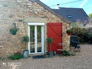 a brick building with a red door and a patio at Le studio Une bulle de douceur in Beaune