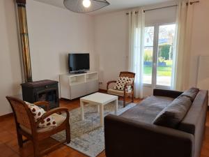 a living room with a couch and a tv at Gîte moderne avec jardin, terrasse et parking privé - FR-1-590-538 in Saint-Sigismond