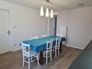 a dining room with a blue table and white chairs at Gîte moderne avec jardin, terrasse et parking privé - FR-1-590-538 in Saint-Sigismond +4 photos