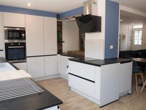 a kitchen with white cabinets and a black counter top at Maison de Ville avec Spa et Sauna près d'Orléans - FR-1-590-547 in Chécy