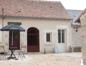 a building with a red door and a table and chairs at Maison de Ville avec Spa et Sauna près d'Orléans - FR-1-590-547 in Chécy