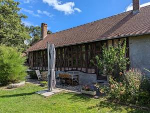 ein Haus mit einem Tisch und Stühlen im Hof in der Unterkunft Longère de charme rénovée, 2 chambres, proche Orléans - FR-1-590-553 in Ligny-le-Ribault