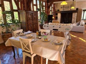 ein Esszimmer mit einem Tisch und Teller mit Lebensmitteln in der Unterkunft Longère de charme rénovée, 2 chambres, proche Orléans - FR-1-590-553 in Ligny-le-Ribault