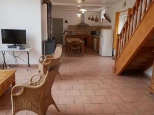 a living room with two chairs and a table and a kitchen at Gîte calme en forêt, proche Gien, 3 chambres et 2 salles d'eau - FR-1-590-555 in Ouzouer-sur-Trézée