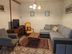 a living room with a couch and a tv at Gîte calme près de Meung-sur-Loire avec jardin et terrasse - FR-1-590-537 in Meung-sur-Loire