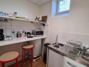 a small kitchen with a counter and two stools at Studio cosy proche d'Orléans avec parking et animaux sur place - FR-1-590-558 in Bucy-Saint-Liphard