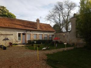 a house with a yard with a dog laying in front of it at Studio cosy proche d'Orléans avec parking et animaux sur place - FR-1-590-558 in Bucy-Saint-Liphard