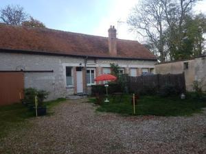 a house with a red umbrella in the yard at Studio cosy proche d'Orléans avec parking et animaux sur place - FR-1-590-558 in Bucy-Saint-Liphard +2 photos