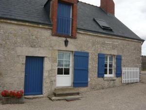 a brick building with blue shutters and a white door at Gîte cosy rénové avec jardin, Wi-Fi et animaux acceptés près d'Orléans - FR-1-590-559 in Épieds-en-Beauce