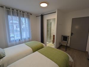 a bedroom with two beds and a window and a chair at Maison rénovée avec jardin et parking, proche Orléans, animaux acceptés - FR-1-590-561 in Épieds-en-Beauce