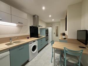 - une cuisine avec un évier et une table avec un lave-linge dans l'établissement Appartement confortable, proche centre-ville, idéal pour 4 personnes - FR-1-489-555, à Moulins