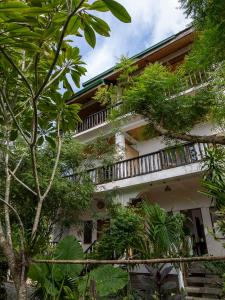 a building with trees and plants in front of it at Golden Monkey Beach Hotel in El Nido