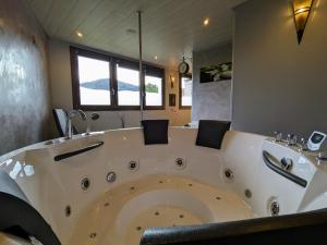 La salle de bains est pourvue d'une grande baignoire blanche. dans l'établissement Cabane perchée avec terrasse, sauna et BBQ à Ferdrupt - FR-1-589-770, à Ferdrupt