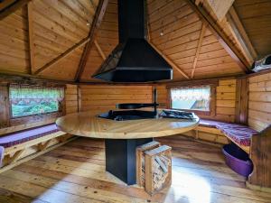 une cuisine avec une cuisinière dans une cabane en bois dans l'établissement Cabane perchée avec terrasse, sauna et BBQ à Ferdrupt - FR-1-589-770, à Ferdrupt