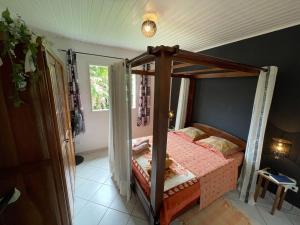 a bedroom with a canopy bed with a window at Gîte 3 épis avec cuisine équipée et centre équestre à proximité - FR-1-786-38 in Saint-Benoît