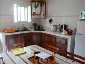 a kitchen with a table and a refrigerator at Gîte 3 épis avec cuisine équipée et centre équestre à proximité - FR-1-786-38 in Saint-Benoît +10 photos