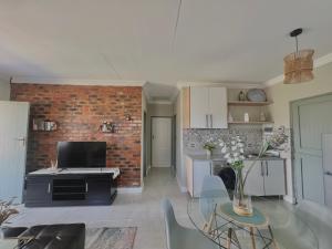 a kitchen and living room with a brick wall at The Cozy Nook @ Skyfall Country Estate in Polokwane