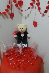 a teddy bear sitting on top of a table with hearts at PREMIER SUITES PLUS Glasgow George Square in Glasgow