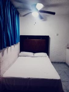 a bed in a room with a ceiling fan at Hotel Acuario in Acapulco