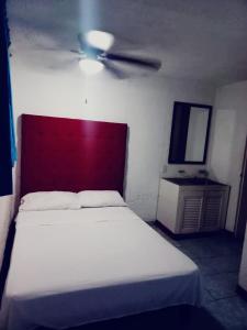 a bedroom with a bed and a ceiling fan at Hotel Acuario in Acapulco
