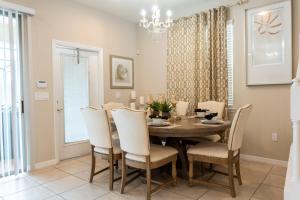 a dining room with a table and chairs at Modern 5BR TwnHome w Private Pool Near Disney 358 in Kissimmee