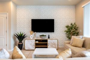 a living room with a flat screen tv on a wall at Modern 5BR TwnHome w Private Pool Near Disney 358 in Kissimmee