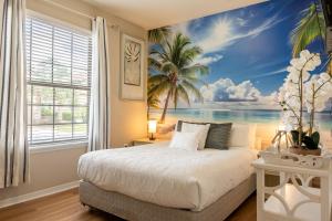 a bedroom with a mural of a beach and palm trees at Modern 5BR TwnHome w Private Pool Near Disney 358 in Kissimmee