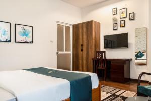 a bedroom with a bed and a desk and a television at Hanoi Bliss Mai Hac De in Hanoi