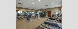 a gym with treadmills and machines in a room at Modern 5BR TwnHome w Private Pool Near Disney 358 in Kissimmee