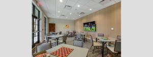 a restaurant with tables and chairs in a room at Modern 5BR TwnHome w Private Pool Near Disney 358 in Kissimmee